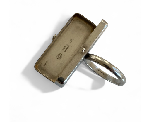 Discover the exquisite Astrid Fog Georg Jensen Pill Box Ring, a unique blend of functionality and elegance. Perfect for storing small treasures or medication, this stunning ring adds a touch of sophistication to any outfit. Shop now and elevate your jewelry collection!